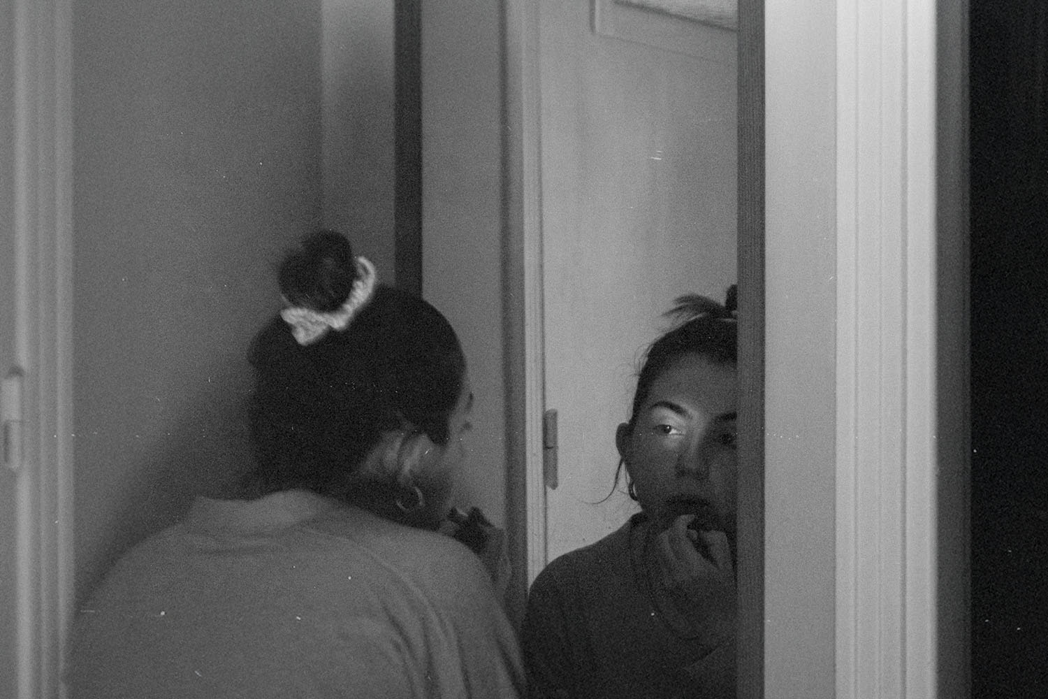 Woman leaning into a mirror putting lipstick on