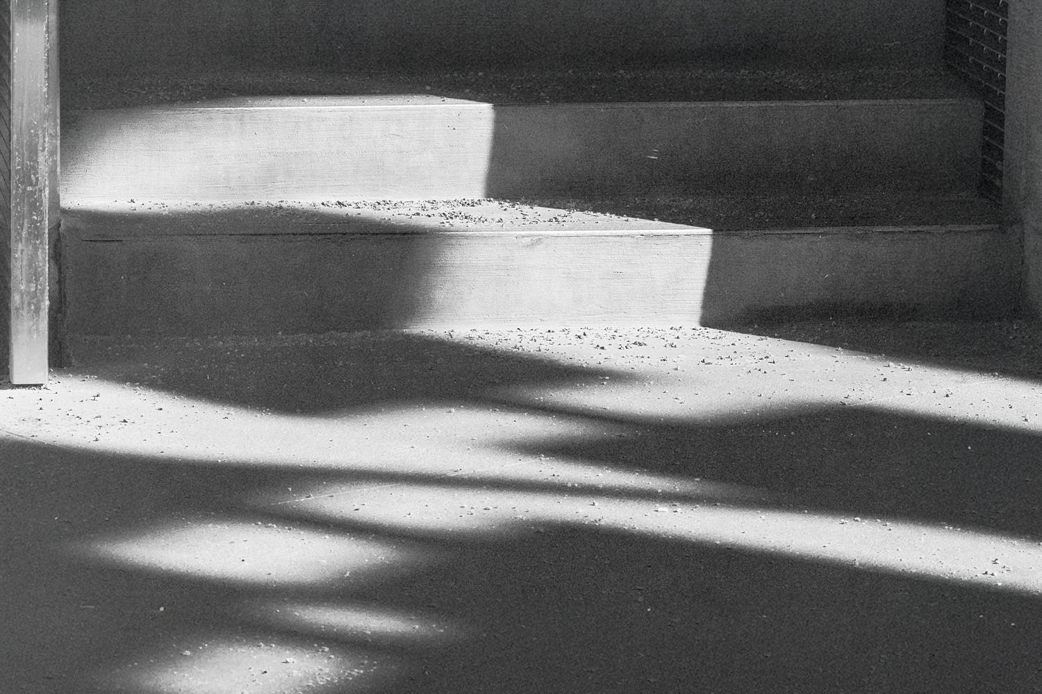 Sunlight casts geometric shadows across a set of concrete steps