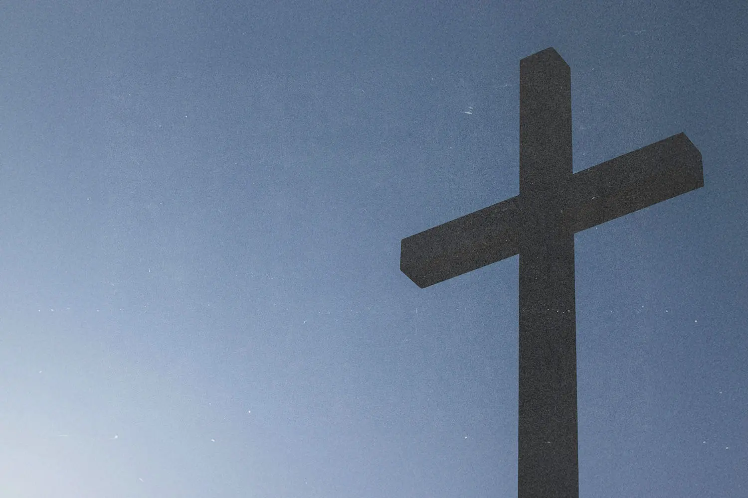 A large cross stands against a clear blue sky