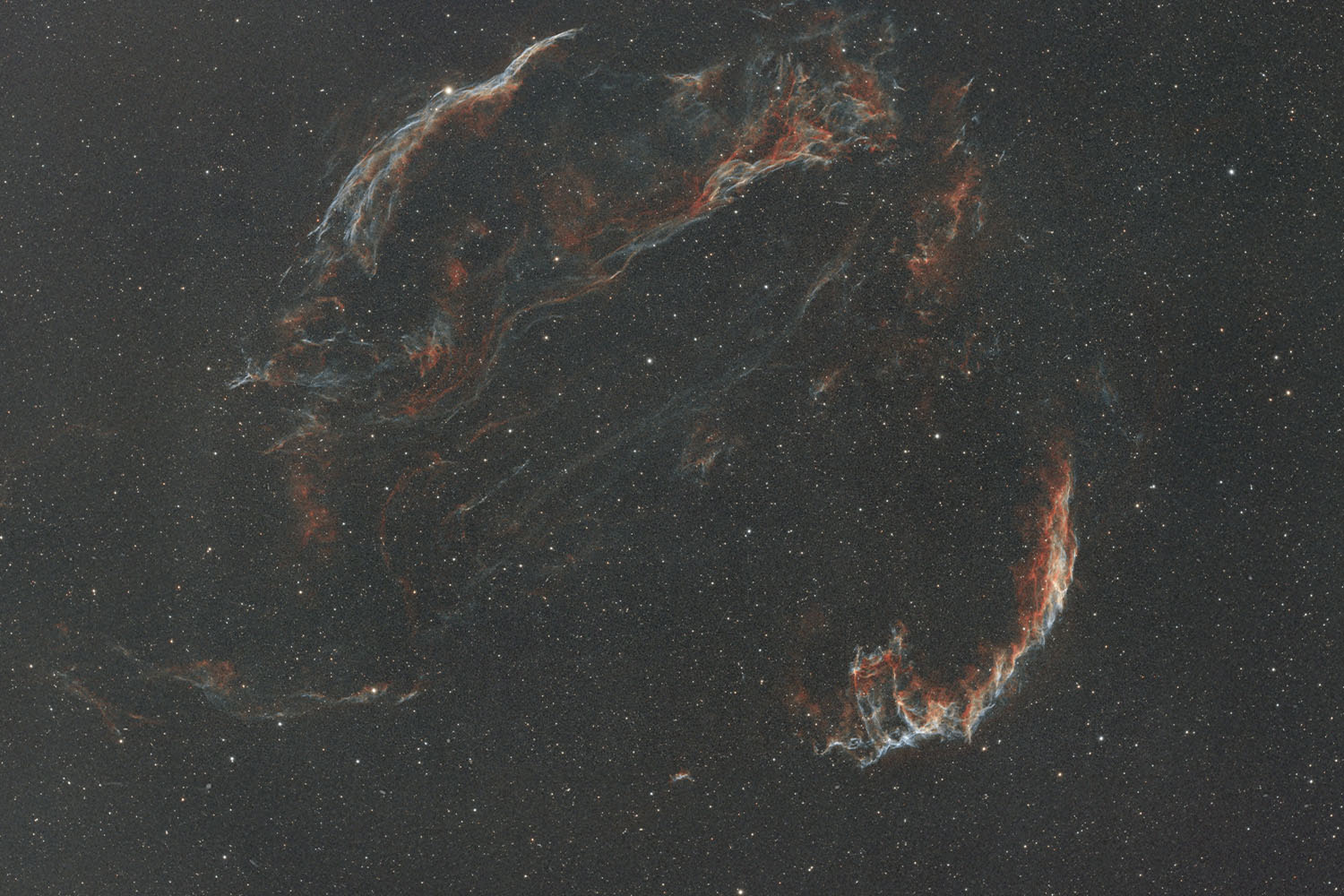 Colorful wisps of a nebula stretching across a star‑filled night sky