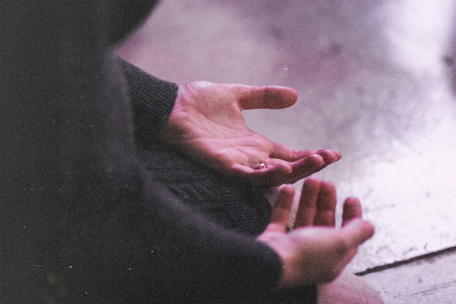 Close-up image of a person's hand resting, palms up, on their lap as they kneel on the floor