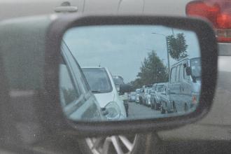 Looking in a rear view car mirror, showing many cars behind