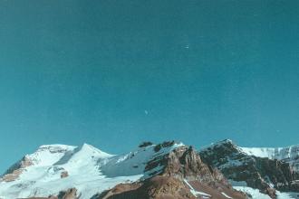 Snow‑covered mountain peaks under a clear blue sky. If you want a more keyword‑rich version (faith, stren