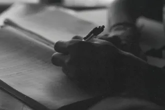 Close‑up of a hand writing in a notebook with soft lighting