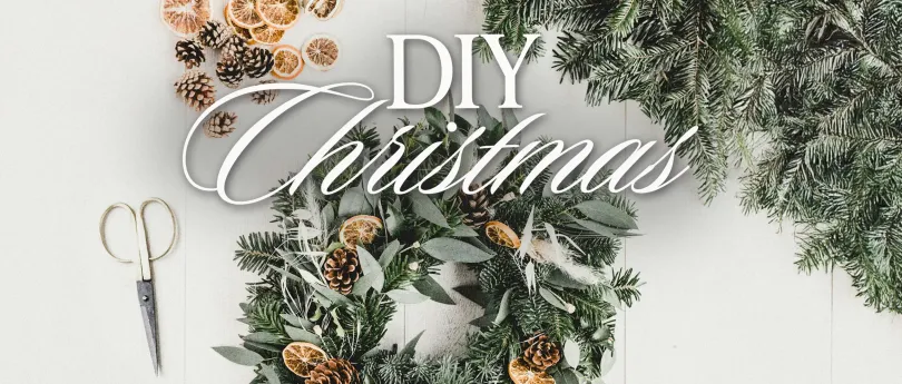 Create festive charm with DIY Christmas ideas like this natural wreath featuring pinecones, dried oranges, and lush greenery.