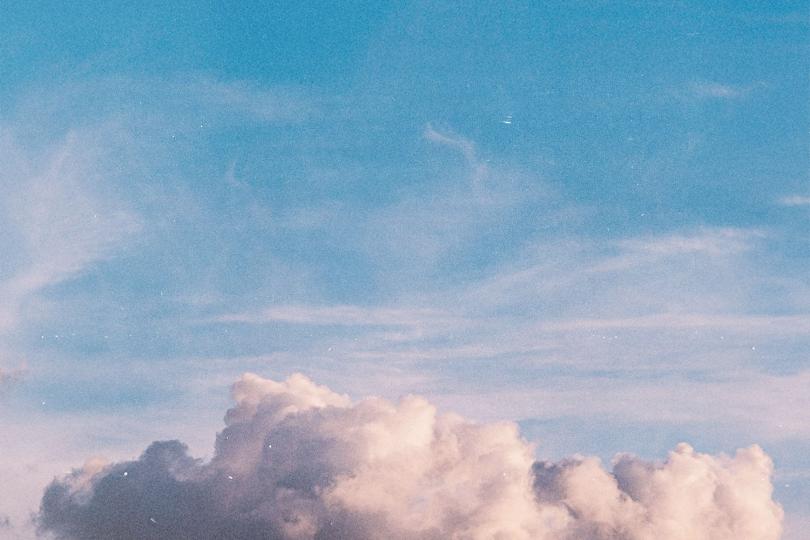 Blue sky filled with soft, bright clouds during a clear daytime scene
