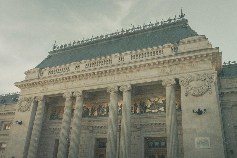 Historic building with tall columns, ornate carvings, and a large decorative frieze above the entrance